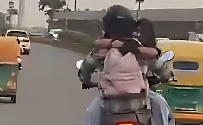 Woman sits on bike’s fuel tank, hugs rider while driving in Delhi; police slams Rs 11,000 fine