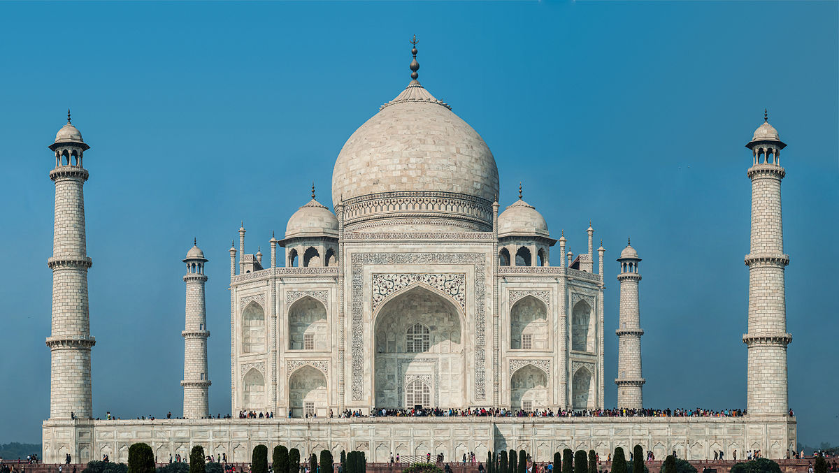 Four people wave saffron flag at Taj Mahal complex; held