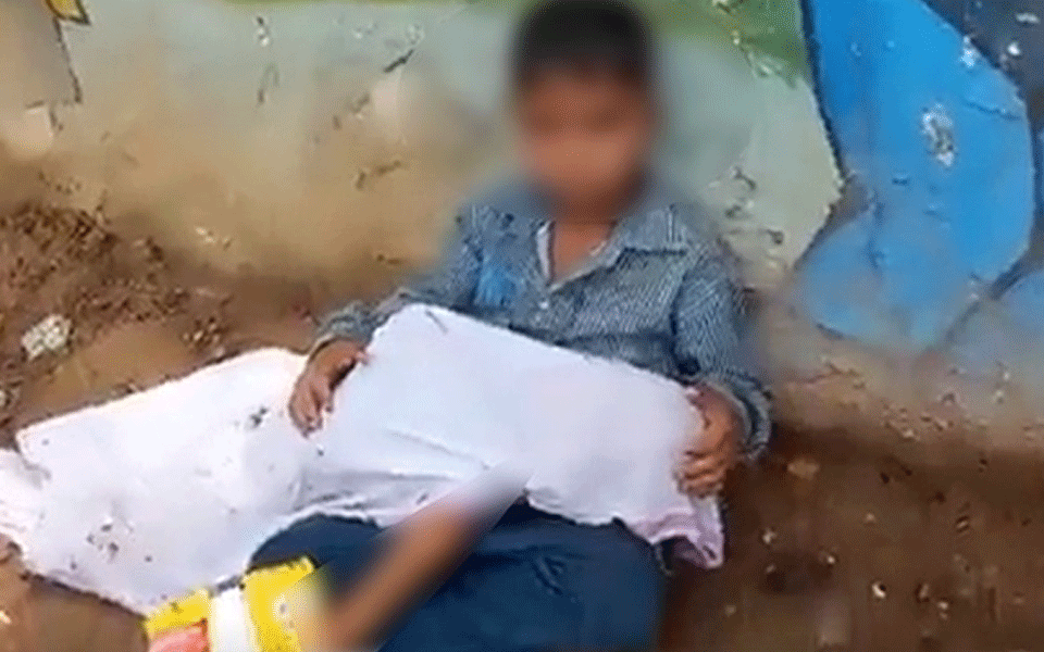 8-yr-old boy sits with younger brother's body in lap outside hospital as father looks for ambulance