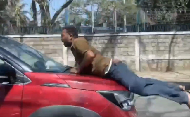 Man dragged on car bonnet in alleged road rage incident, driver detained